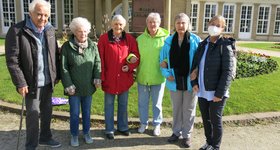 6 Seniorinnen und Senioren in Herbstjacken stehen vor dem Kursaal