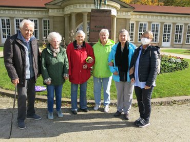 6 Seniorinnen und Senioren in Herbstjacken stehen vor dem Kursaal
