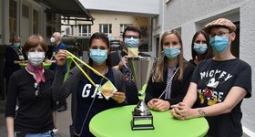 6 Personen an einem Stehtisch mit Pokal