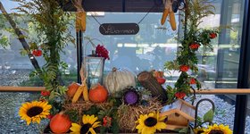 Planwagen mit Holzdach und Herbstdeko aus Sonnenblumen, Stroh und Kürbissen