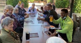 Gruppe von Seniorinnen und Senioren beim Mittagessen im Freien